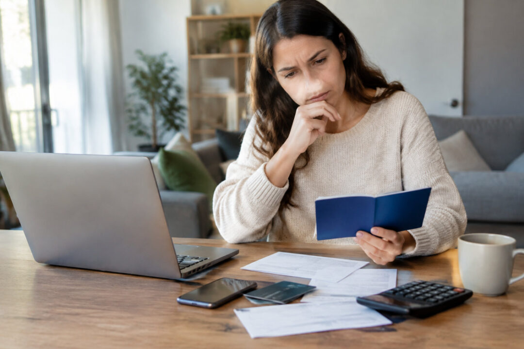 Épargnant vérifiant un faux site de banque pour éviter une arnaque livret épargne